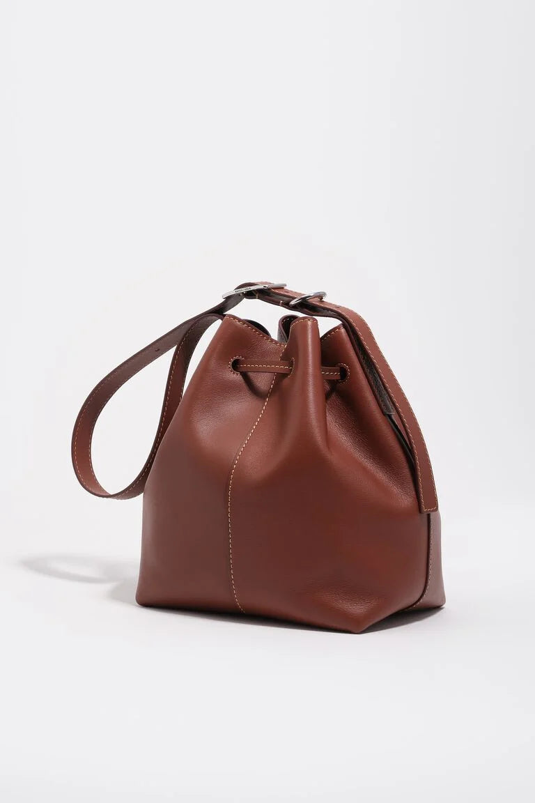 תיק דלי עור חום עם רצועה ארוכה, עיצוב אלגנטי, צילום על רקע לבן