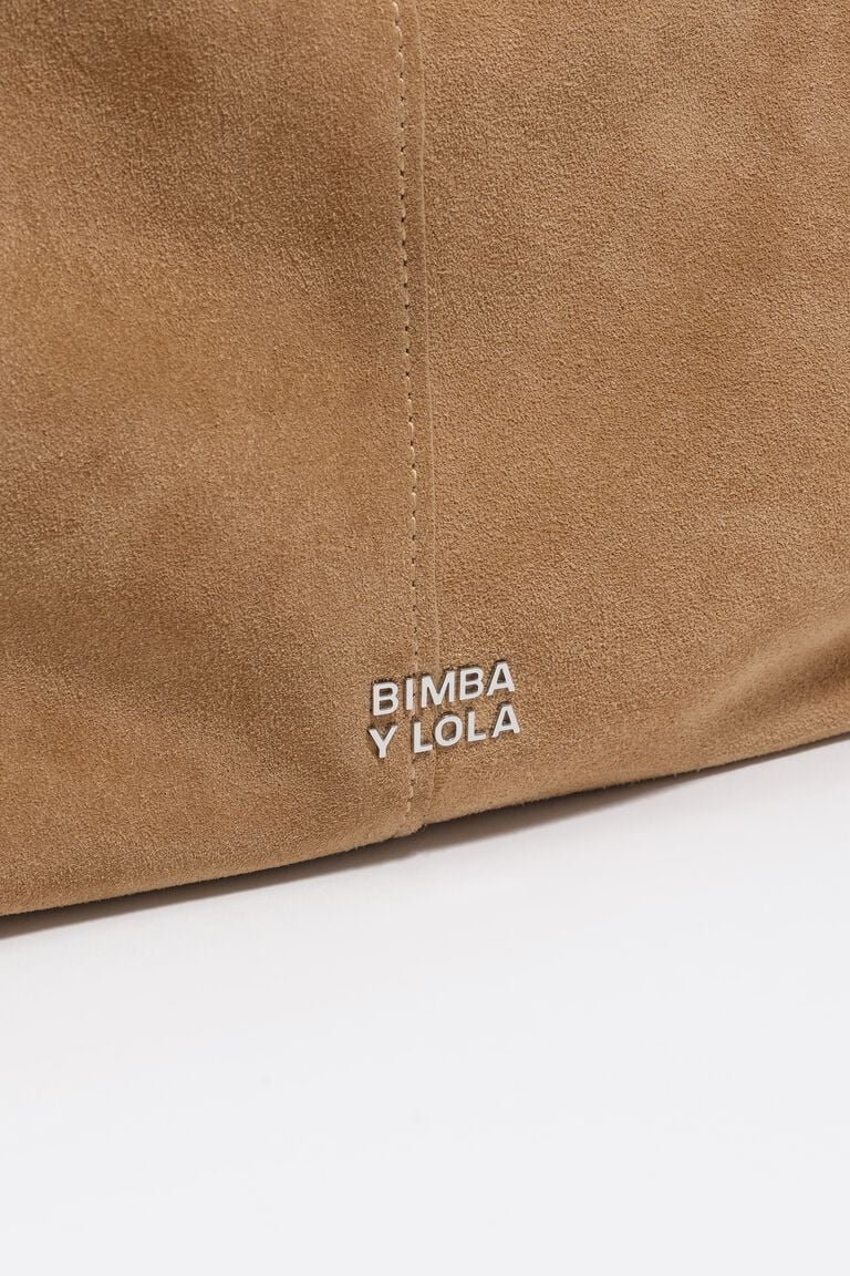 תקריב על תיק זמש חום עם כיתוב BIMBA Y LOLA, עיצוב יוקרתי ואופנתי