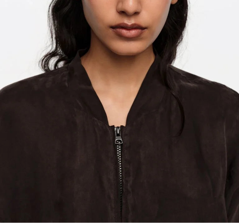 אישה לובשת ז'קט שחור עם רוכסן, תקריב על חלק עליון, אופנה לנשים