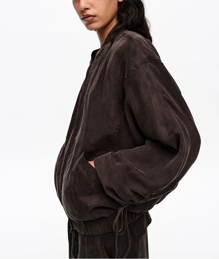 דוגמן לובש מעיל בומבר חום כהה, כיסים קדמיים, רקע לבן, אופנה מודרנית לגברים