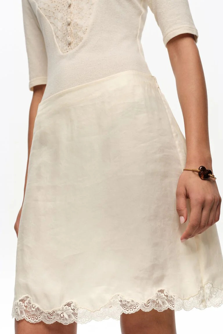 חצאית קצרה בצבע שמנת עם תחרה עדינה בקצה, אופנה אלגנטית לנשים