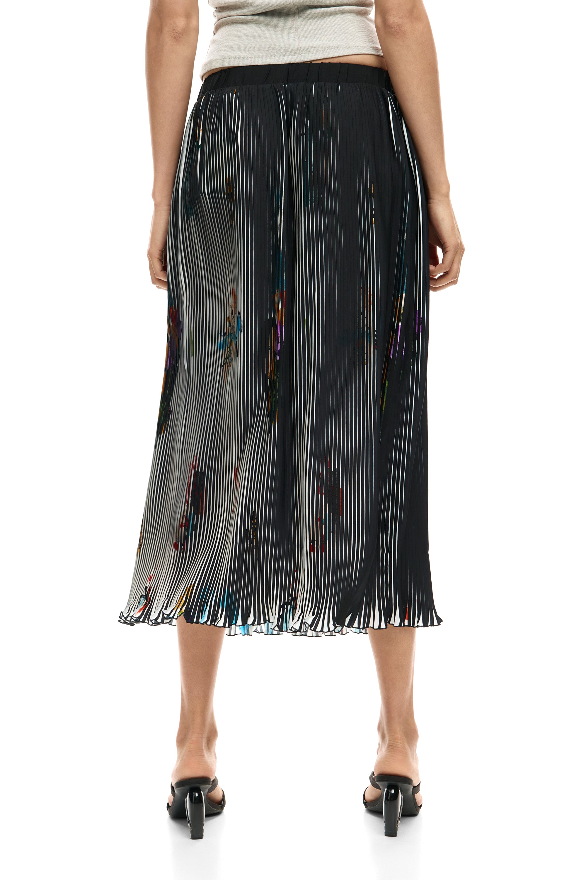 חצאית פליסה שחורה באורך מידי עם דוגמת פסים לבנים ונגיעות צבע, מצולמת מאחור על דוגמנית