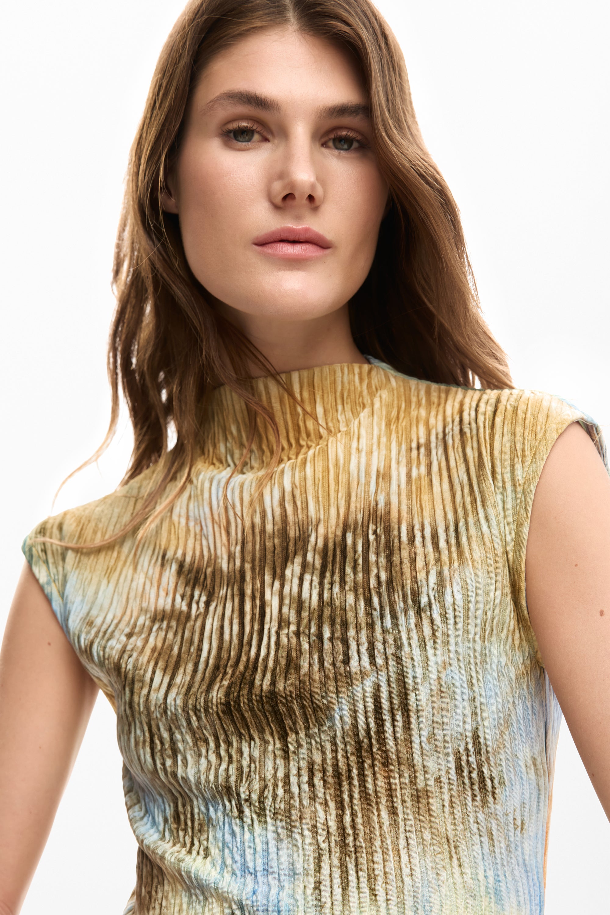 דוגמנית לובשת חולצת נשים קפלים בגווני חום תכלת וצהוב, מראה אופנתי מודרני