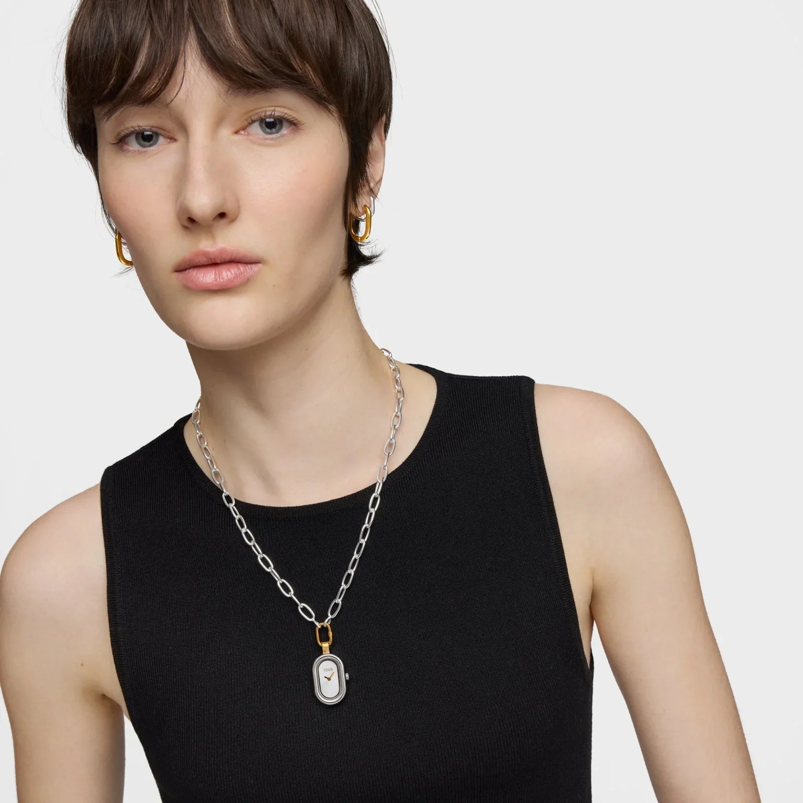 דוגמנית לובשת טופ שחור עם שרשרת כסף ותליון שעון אופנתי, עגילי זהב, צילום CHOZEN