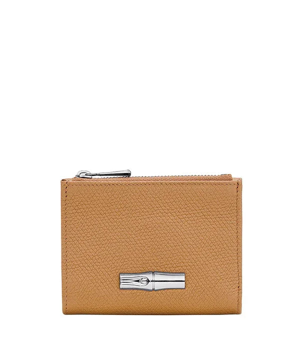 ארנק עור חום יוקרתי עם סמל מתכת, מצולם על רקע לבן, קולקציית CHOZEN