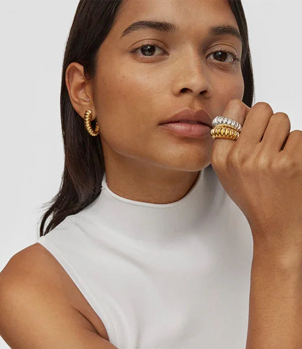 אישה עם עגילי זהב, טבעות עבות זהב וכסף, לובשת חולצה לבנה, צילום תדמית לאופנה CHOZEN