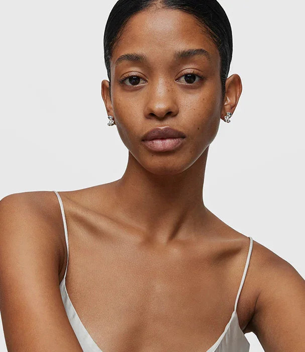 דוגמנית עם עגילי כסף, שמלה לבנה אלגנטית, קמפיין CHOZEN מותגים מובילים