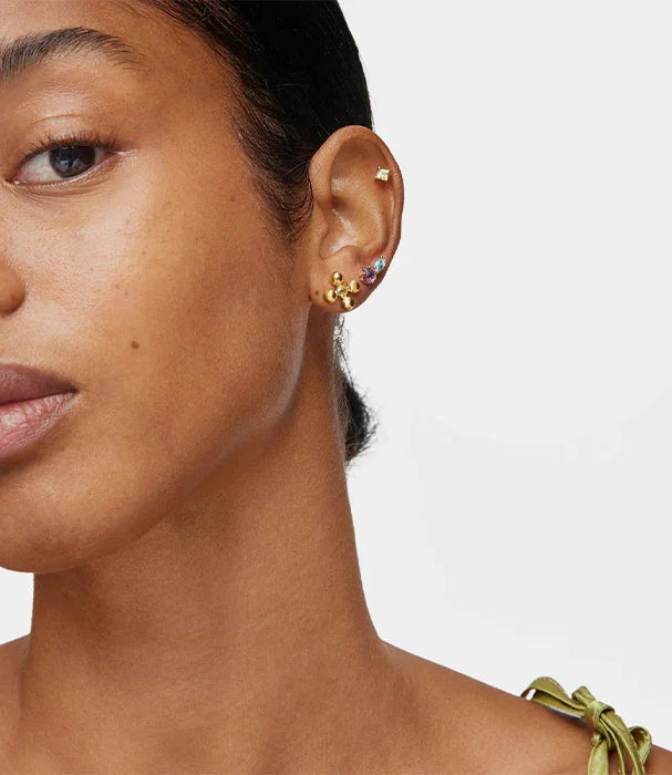 אישה עם עגילי זהב מעוצבים באוזן, תצוגת תכשיטים של CHOZEN מבית קבוצת אלפא