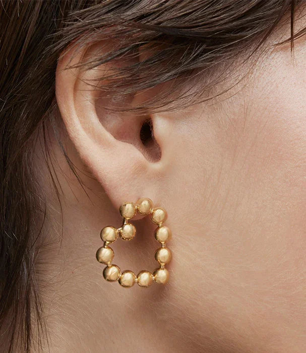 עגיל זהב תליון בצורת לב, עיצוב מודרני, צילום תקריב של האוזן, מותגים מובילים CHOZEN