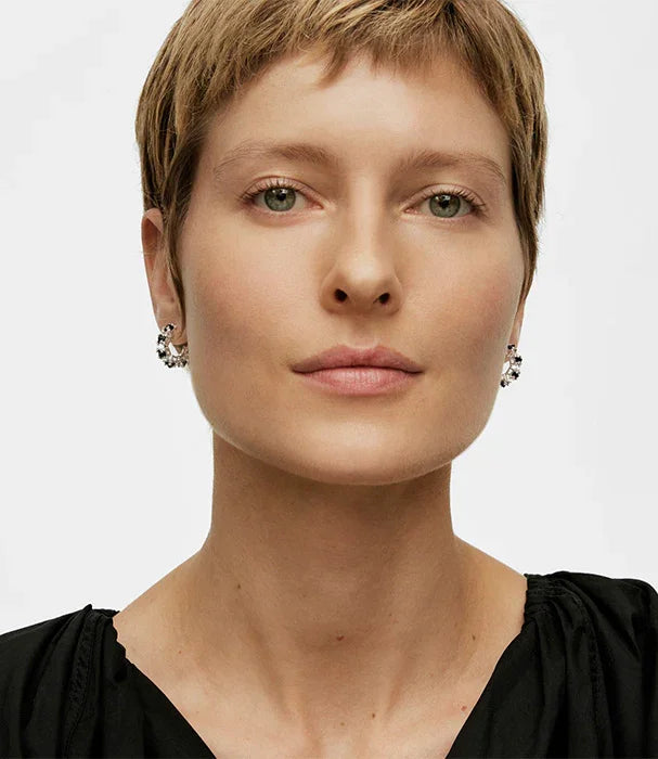 דוגמנית עם שיער קצר עונדת עגילי יוקרה כסף, צילום סטודיו בהשראת מותגים מובילים מבית CHOZEN