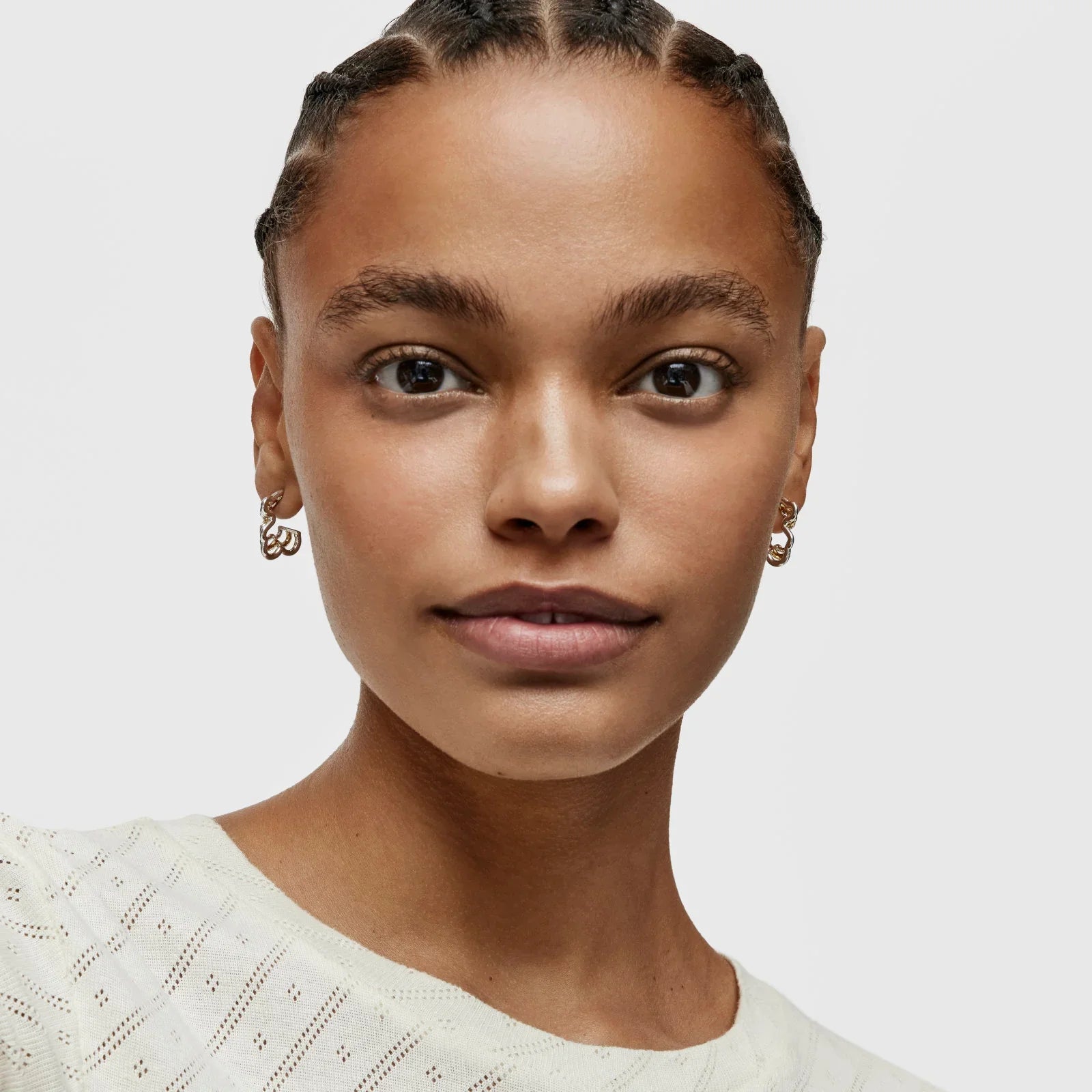 אישה צעירה עונדת עגילים זהב, צילום תקריב, CHOZEN קולקציית תכשיטים אופנתית