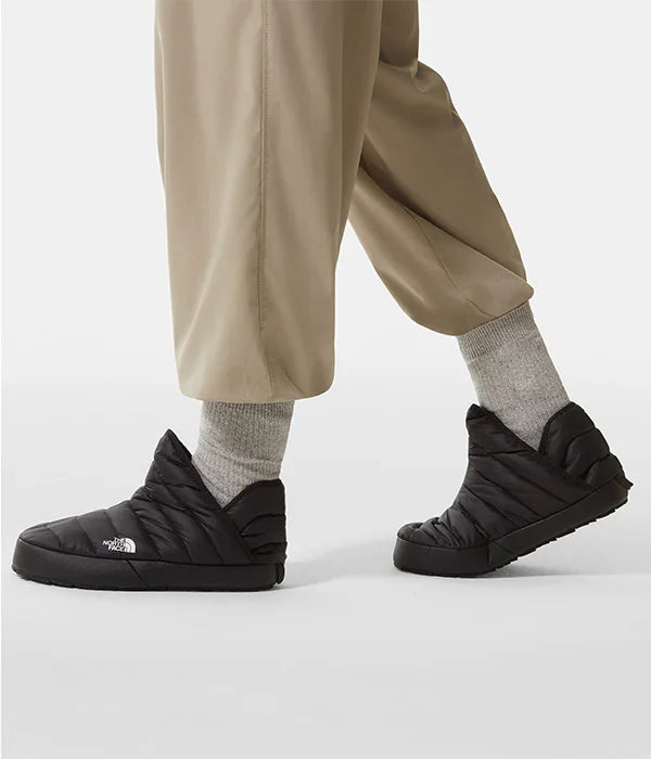 נעלי בית שחורות The North Face על רגליים עם גרביים אפורות ומכנסיים בז', CHOZEN