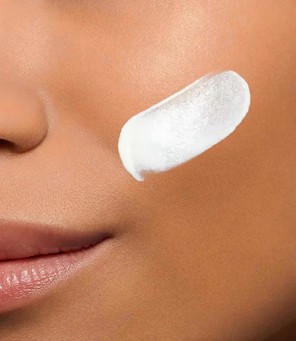 פריימר לבן של מותג מוביל מקבוצת אלפא על לחי אישה, צילום תקריב לעור פנים בריא