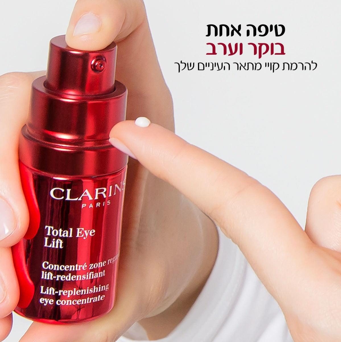 בקבוק סרום עיניים אדום של קלרינס Total Eye Lift ביד, טיפה על אצבע, מוצר טיפוח לעיניים
