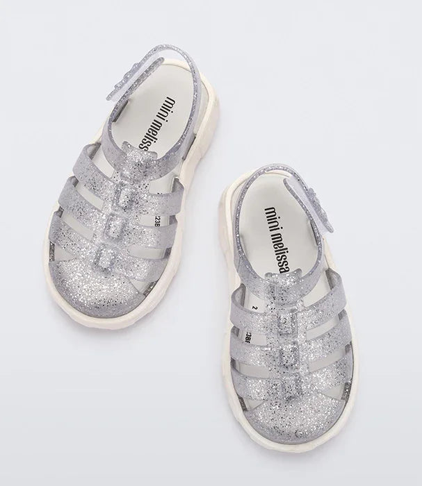 סנדלי ילדים כסופים מנצנצים mini melissa על רקע לבן, מבית המותגים של קבוצת אלפא