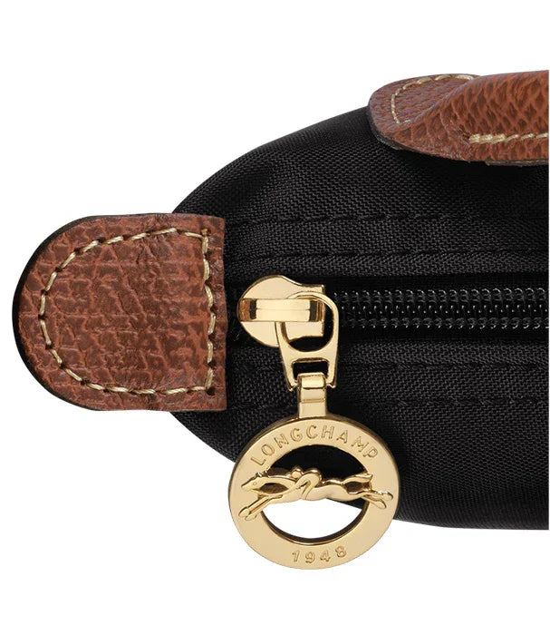 רוכסן זהב עם תג LONGCHAMP על תיק שחור עם גימור עור חום, מבית קבוצת אלפא CHOZEN
