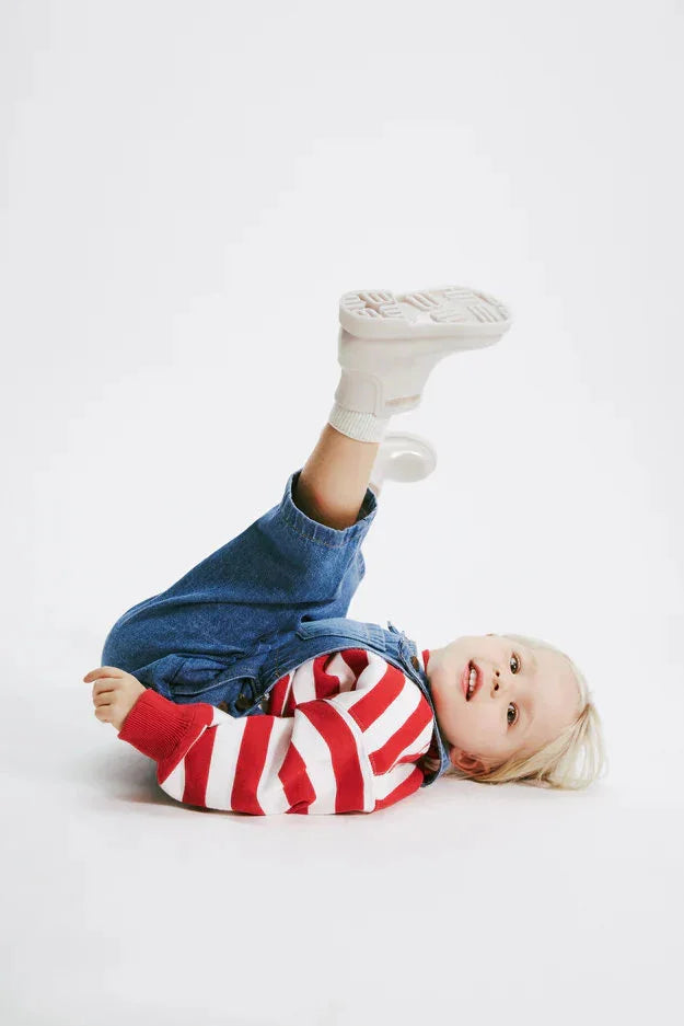 ילד בלבוש ג'ינס וחולצה פסים שוכב על הרצפה, אופנה לילדים CHOZEN, קבוצת אלפא