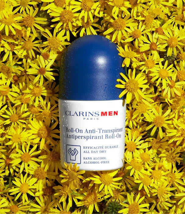 דאודורנט רול און קלרינס לגברים Clarins Men מונח בין פרחי בר צהובים, מבית CHOZEN