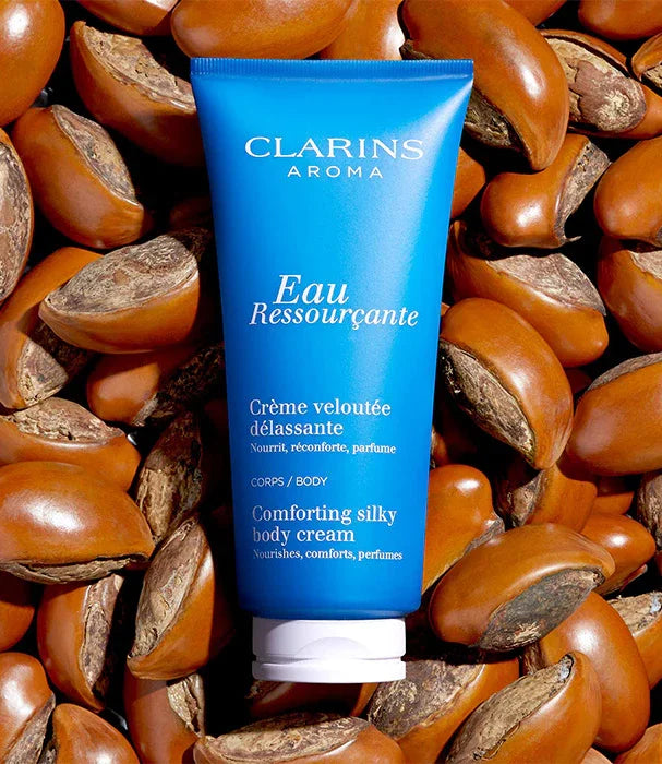 קרם גוף קלרינס Eau Ressourçante בצבע כחול על רקע אגוזים, מוצר טיפוח איכותי מבית CHOZEN