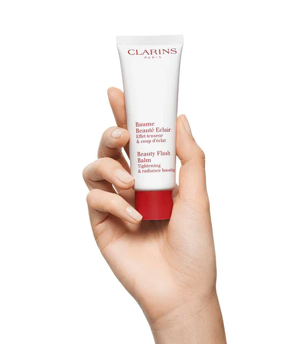 יד מחזיקה קרם Clarins Beauty Flash Balm מוצר טיפוח יוקרה מבית המותגים המובילים ב-CHOZEN