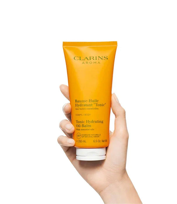 יד מחזיקה באלם גוף לחות של קלרינס Clarins, מוצר יוקרה מבית היבואן הרשמי קבוצת אלפא