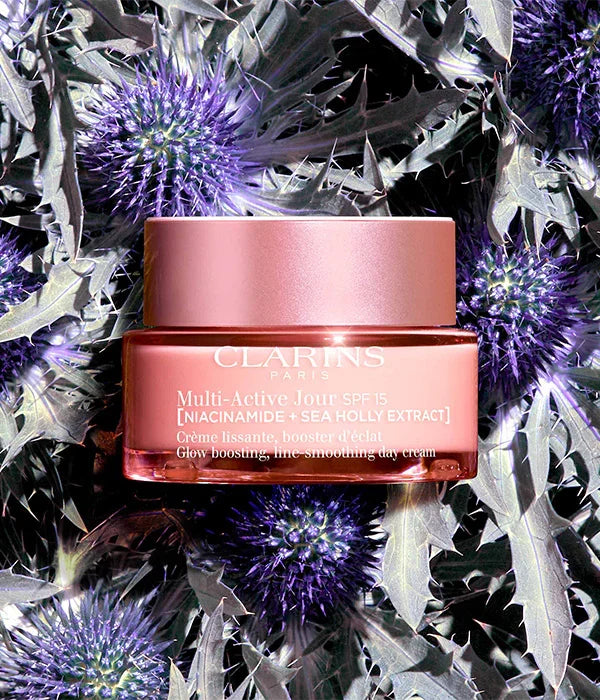 קרם יום Clarins Multi-Active Jour מוצג על רקע פרחי קוציץ, מוצר טיפוח יוקרתי ב-CHOZEN