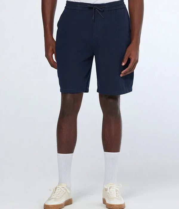 גבר לובש מכנסיים קצרים כחולים, גרביים לבנים ונעלי ספורט, רקע סטודיו, CHOZEN