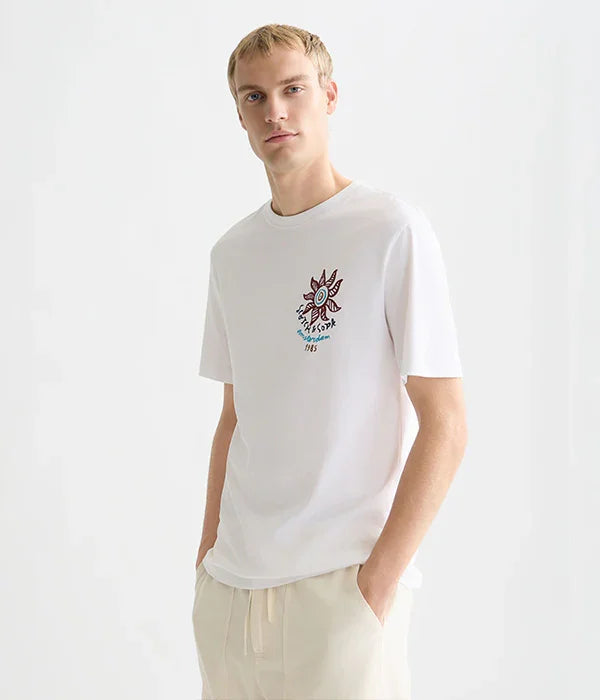 גבר מדגמן חולצה לבנה עם הדפס גרפי צבעוני, אופנה עדכנית של המותגים המובילים ב-CHOZEN