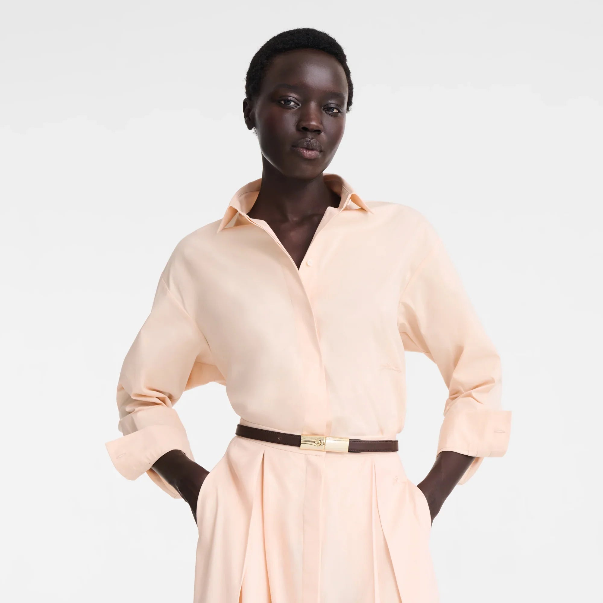 דוגמנית עם חולצה ומכנסיים בצבע בז' בהפקת אופנה ל-CHOZEN, סטייל קז'ואל אלגנטי