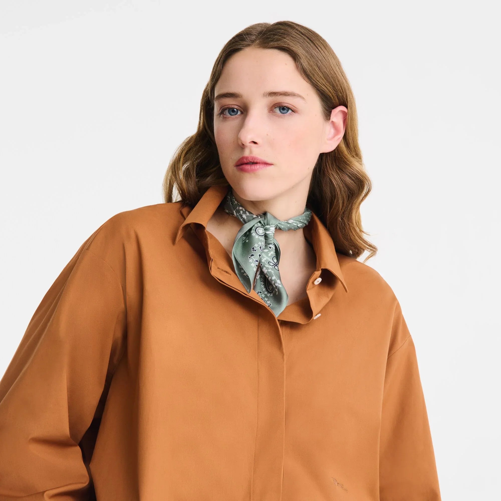 אישה בחולצה חומה וצעיף ירוק, אופנה עדכנית CHOZEN מבית קבוצת אלפא