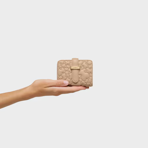 ארנק בז' מעוצב עם דוגמת לוגו, מוחזק ביד על רקע לבן, CHOZEN מותגים מובילים