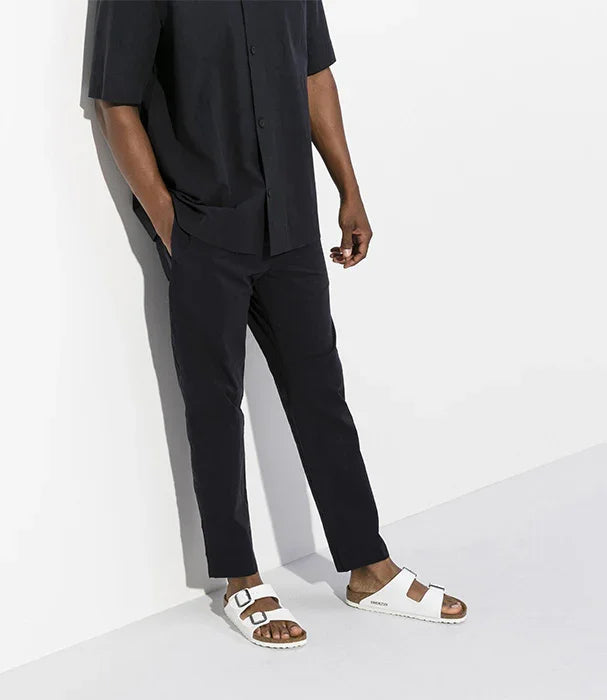 גבר לבוש בגדים שחורים עם כפכפי בירקנשטוק לבנים, צילום אופנה CHOZEN