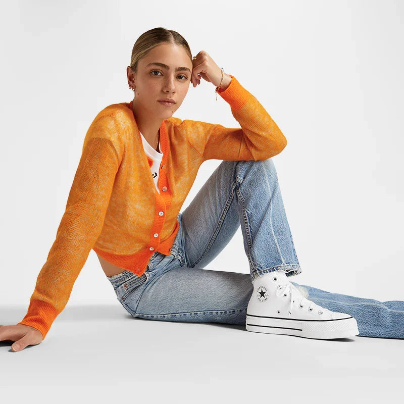 אישה לובשת קרדיגן כתום, ג'ינס ונעלי קונברס לבנות, צילום אופנה CHOZEN