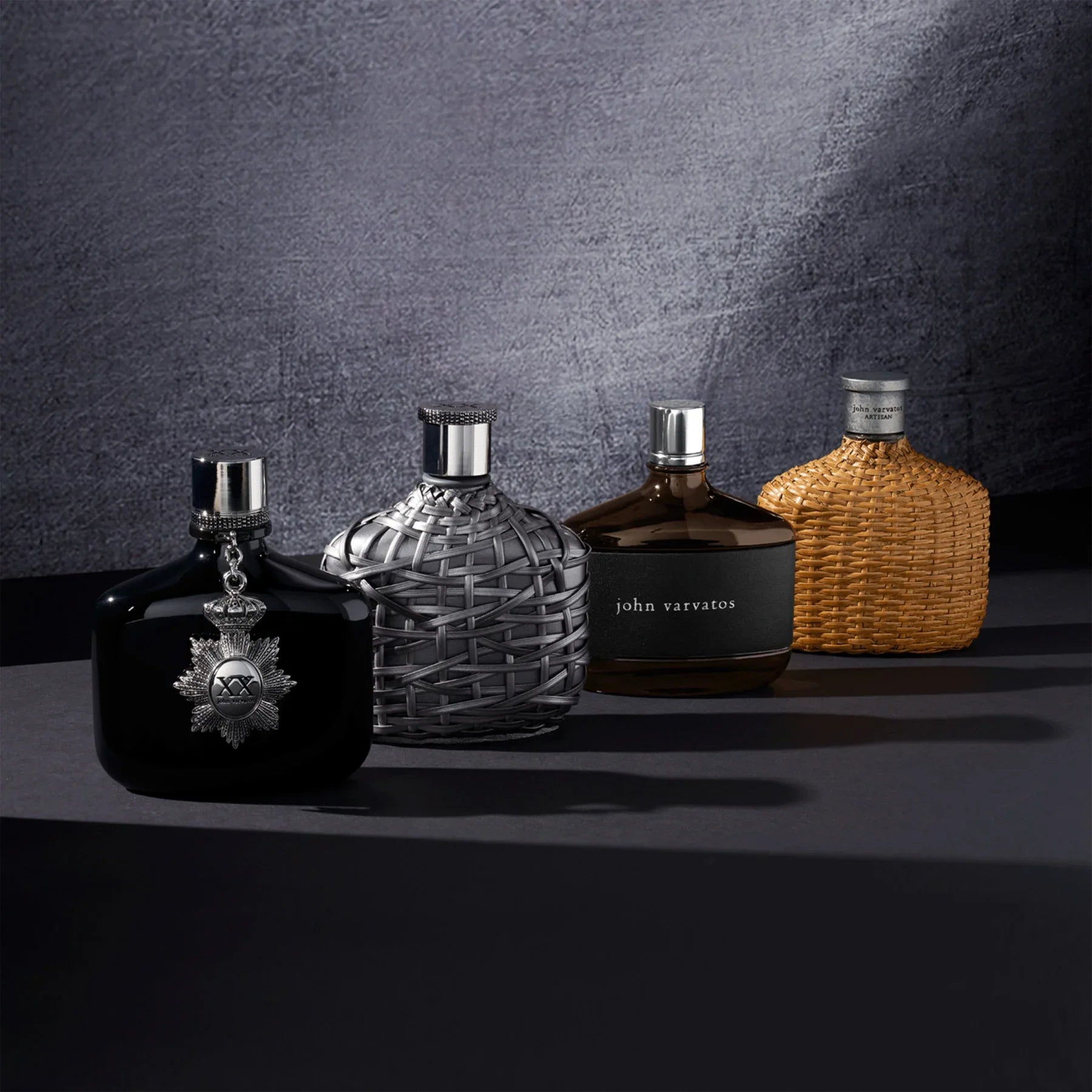 בקבוקי בושם יוקרתיים של המותג john varvatos על רקע כהה, מבית CHOZEN אלפא