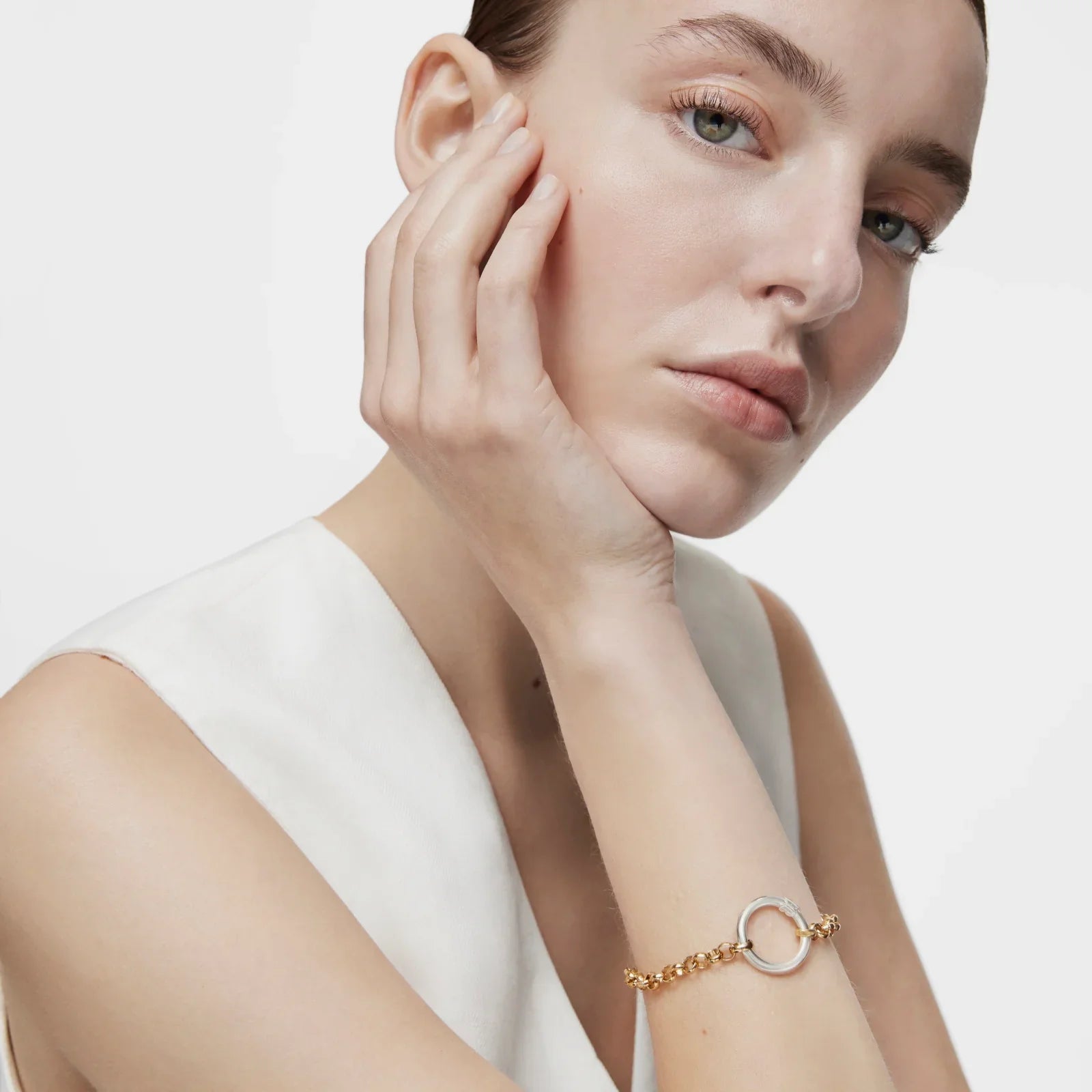 דוגמנית עונדת צמיד זהב עם טבעת עגולה, צילום תקריב, תכשיטים יוקרתיים CHOZEN