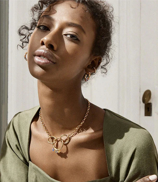 אישה עונדת עגילים ושרשרת זהב אופנתיים, תכשיטי יוקרה מבית CHOZEN