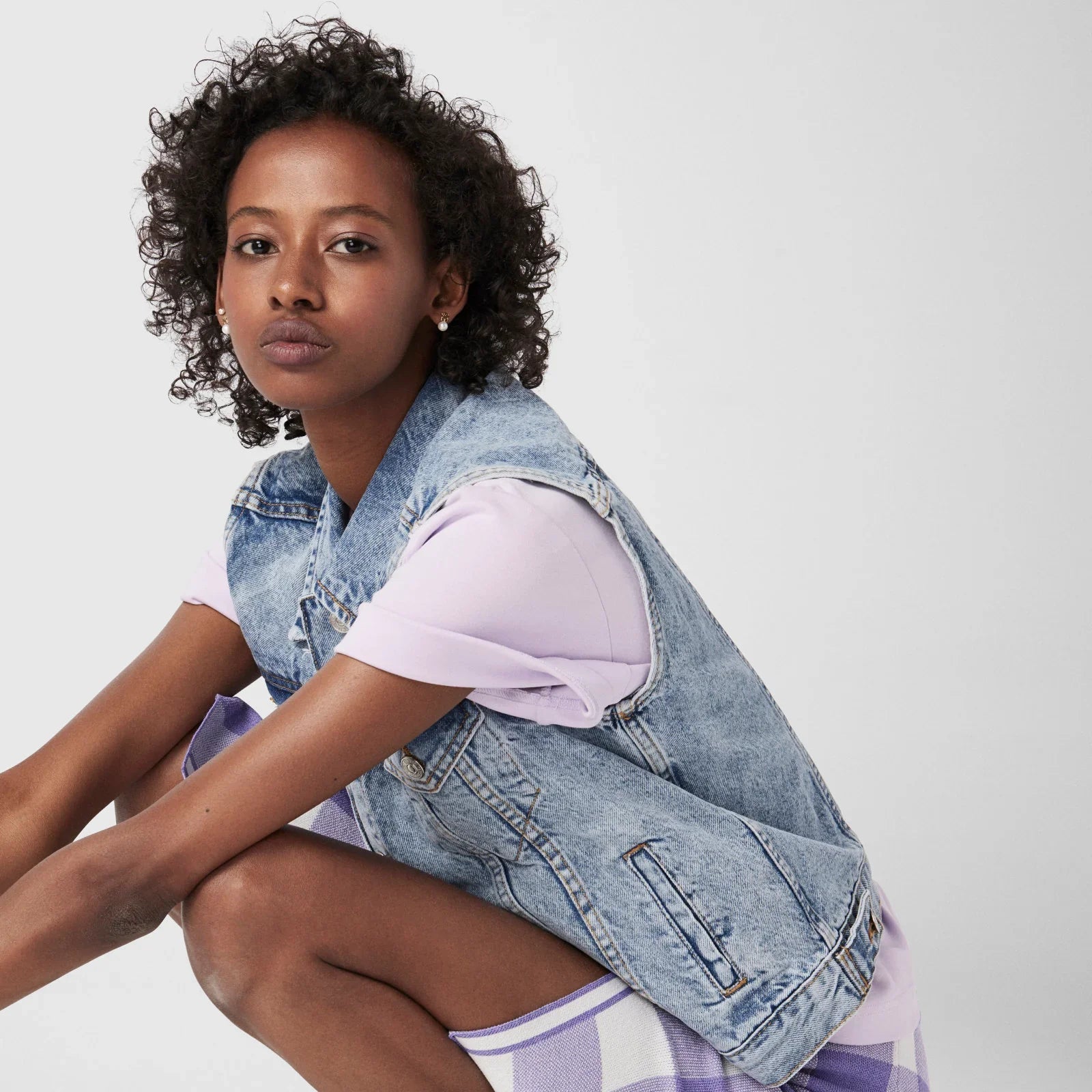 אישה צעירה עם אפודת ג'ינס אופנתית ולבוש סגול, צילום אופנה ל-CHOZEN