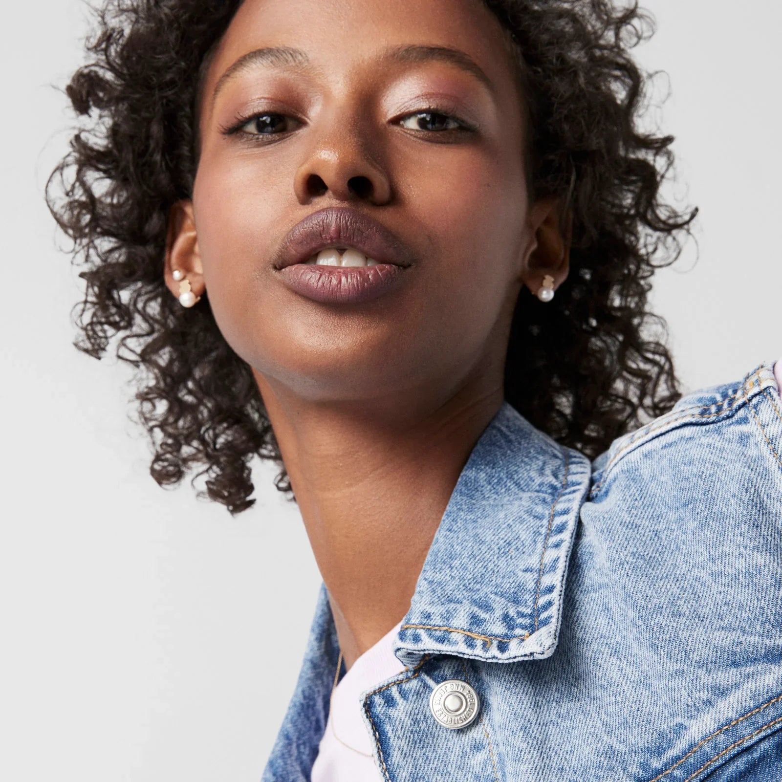 אישה לובשת ג'קט ג'ינס, תקריב אופנתי, רקע בהיר, קמפיין מותגי אופנה CHOZEN