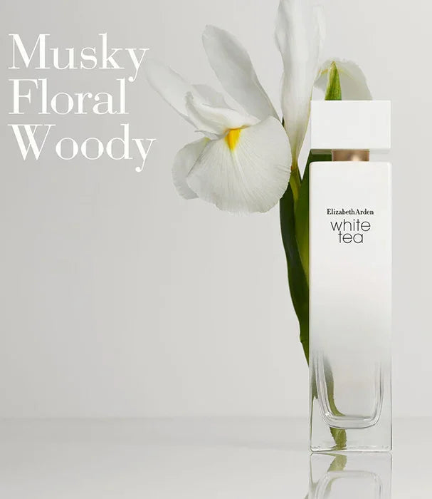 בקבוק בושם Elizabeth Arden White Tea ליד פרח לבן על רקע בהיר, מושלם לניחוח פרחוני ומאסקי