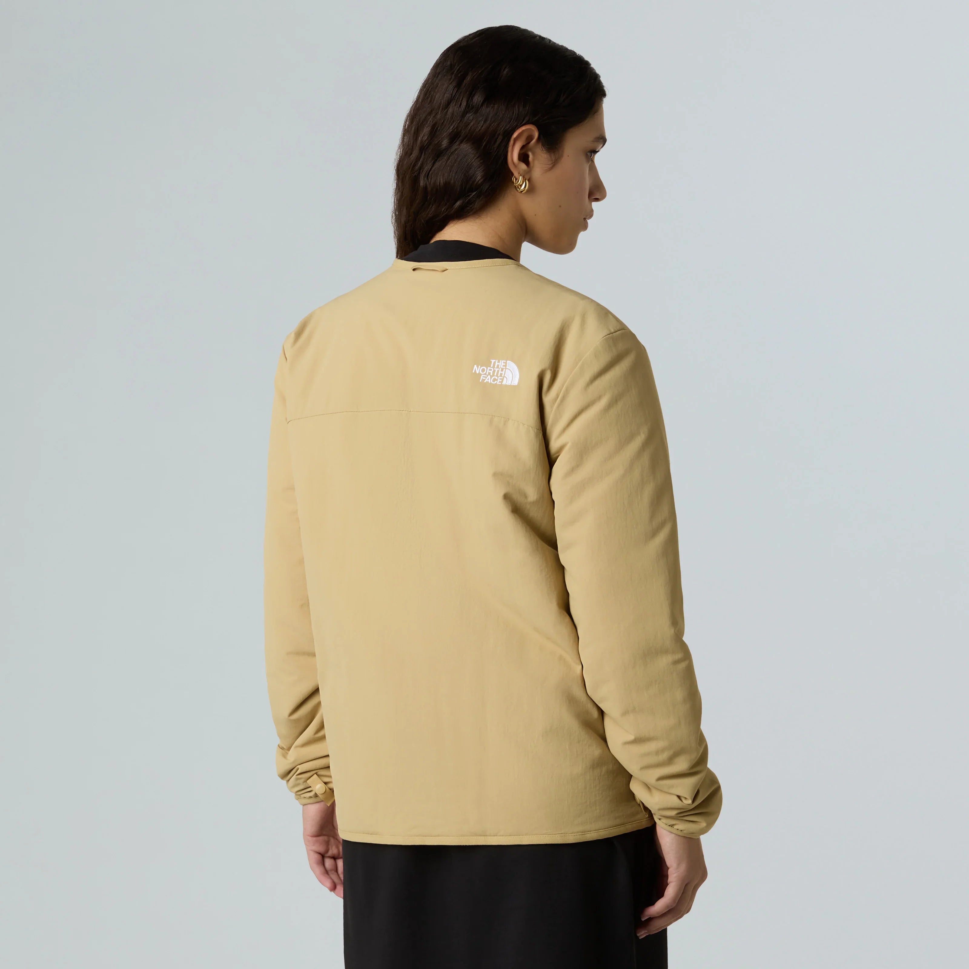 אישה עם מעיל בז' של The North Face, אופנת מותגים, צילום אחורי, CHOZEN