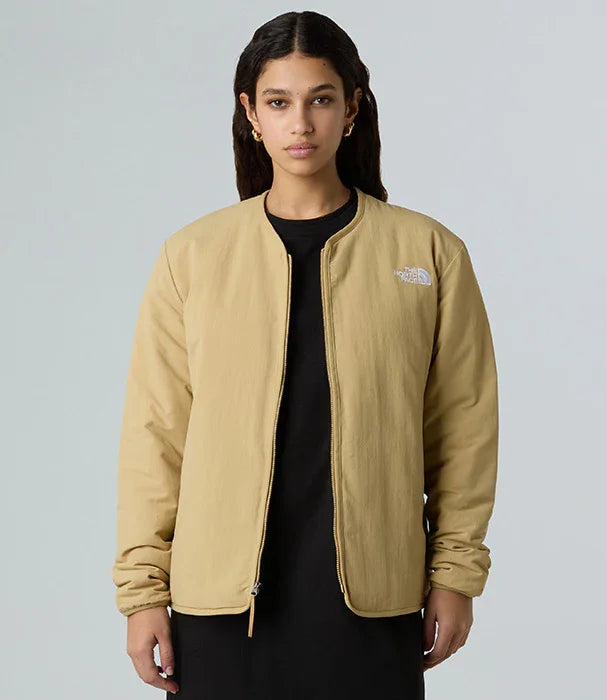 אישה לובשת ג'קט בז' של The North Face מקולקציית CHOZEN, רקע סטודיו חלק