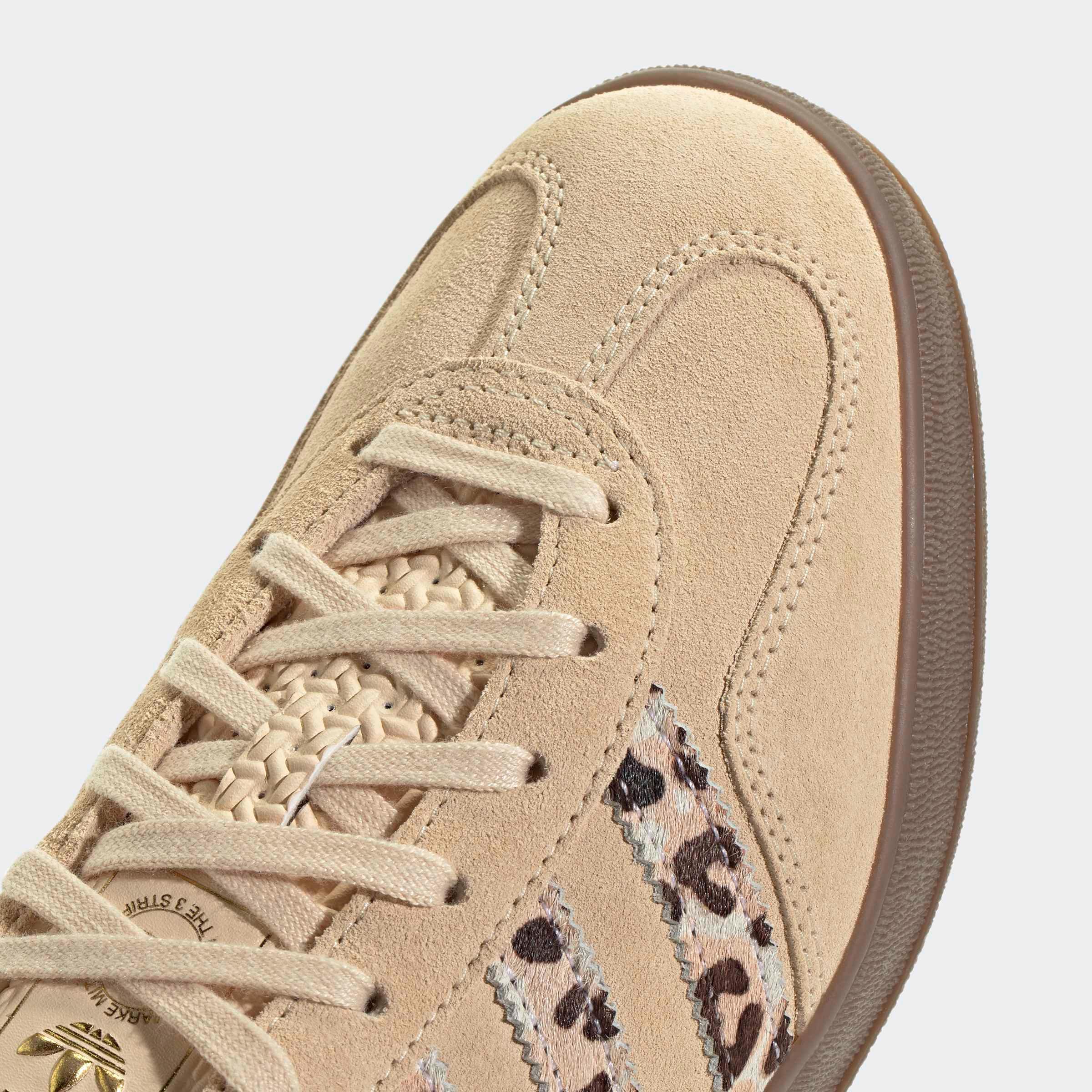 סניקרס בז׳ זמש עם פסים מנומרים, צילום תקריב, נעלי מותג ב-CHOZEN