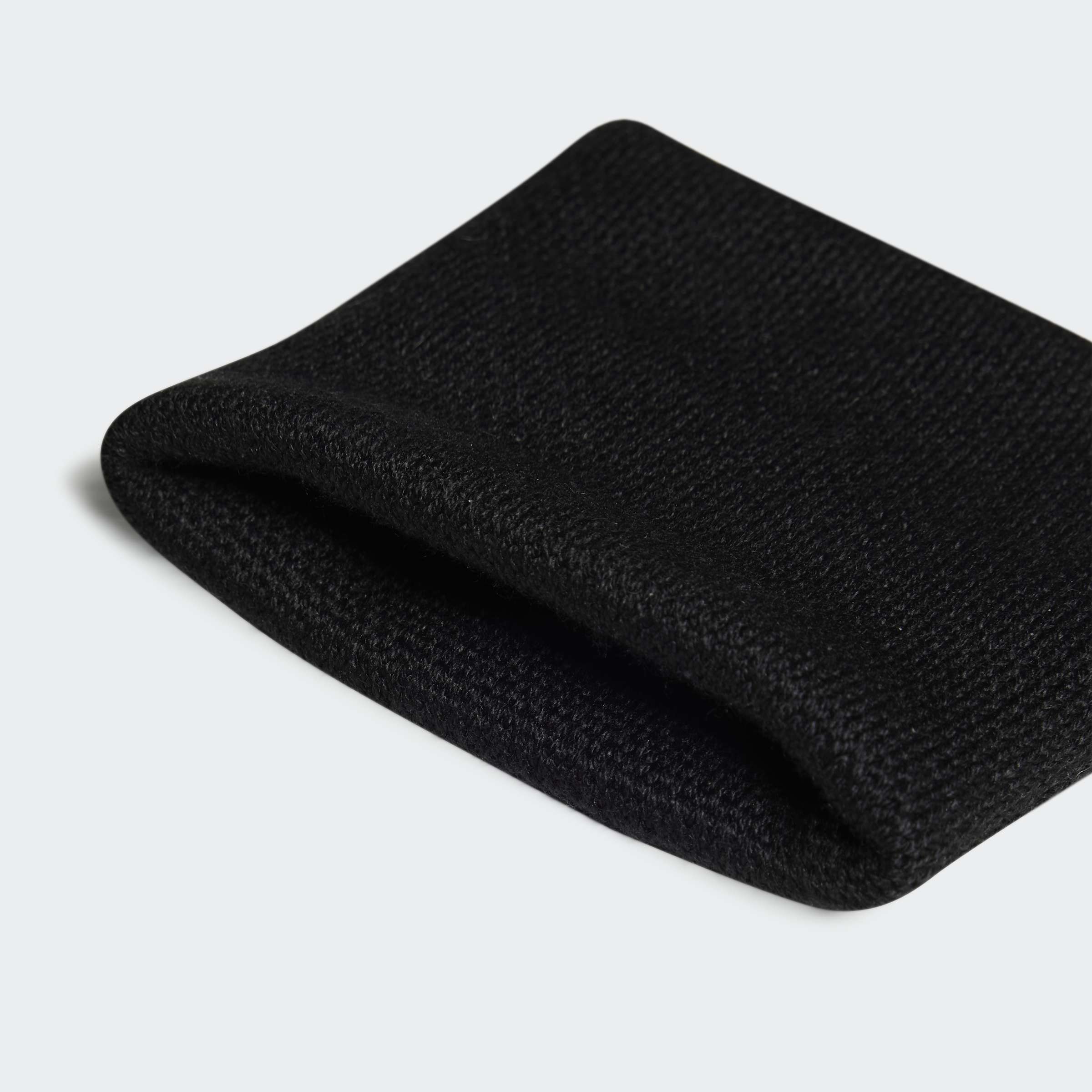 תקריב של בד שחור סרוג, מרקם מחוספס, צילום מוצר על רקע בהיר