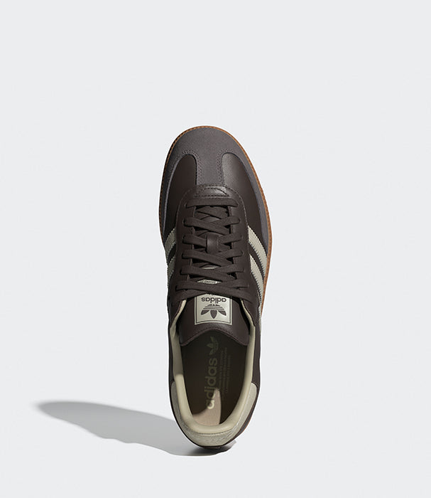 נעל ספורט חומה עם פסי צד לבנים, צילום עליון על רקע לבן