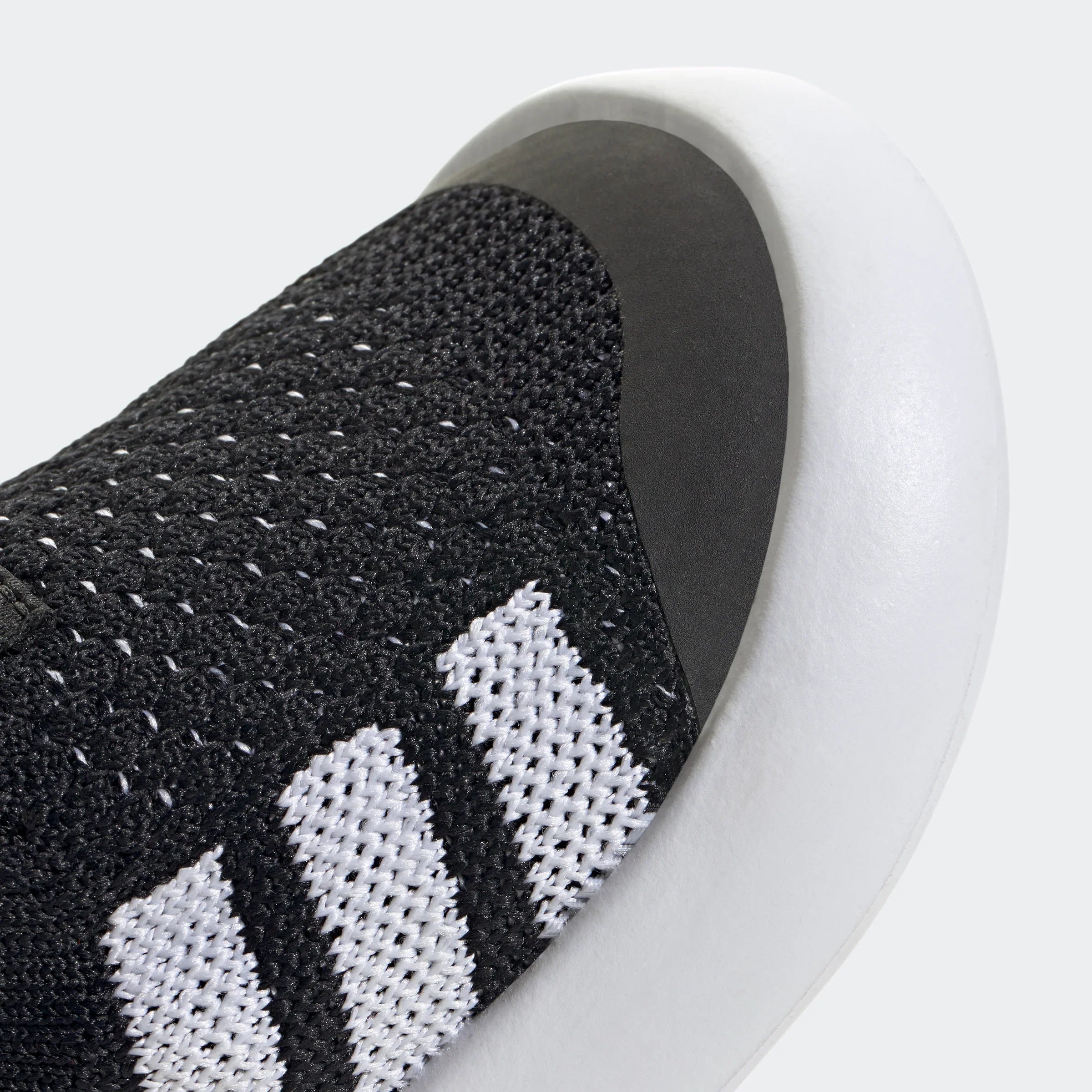 תקריב נעל ספורט שחורה עם שלושה פסים לבנים וסוליה לבנה, CHOZEN מותגים מובילים