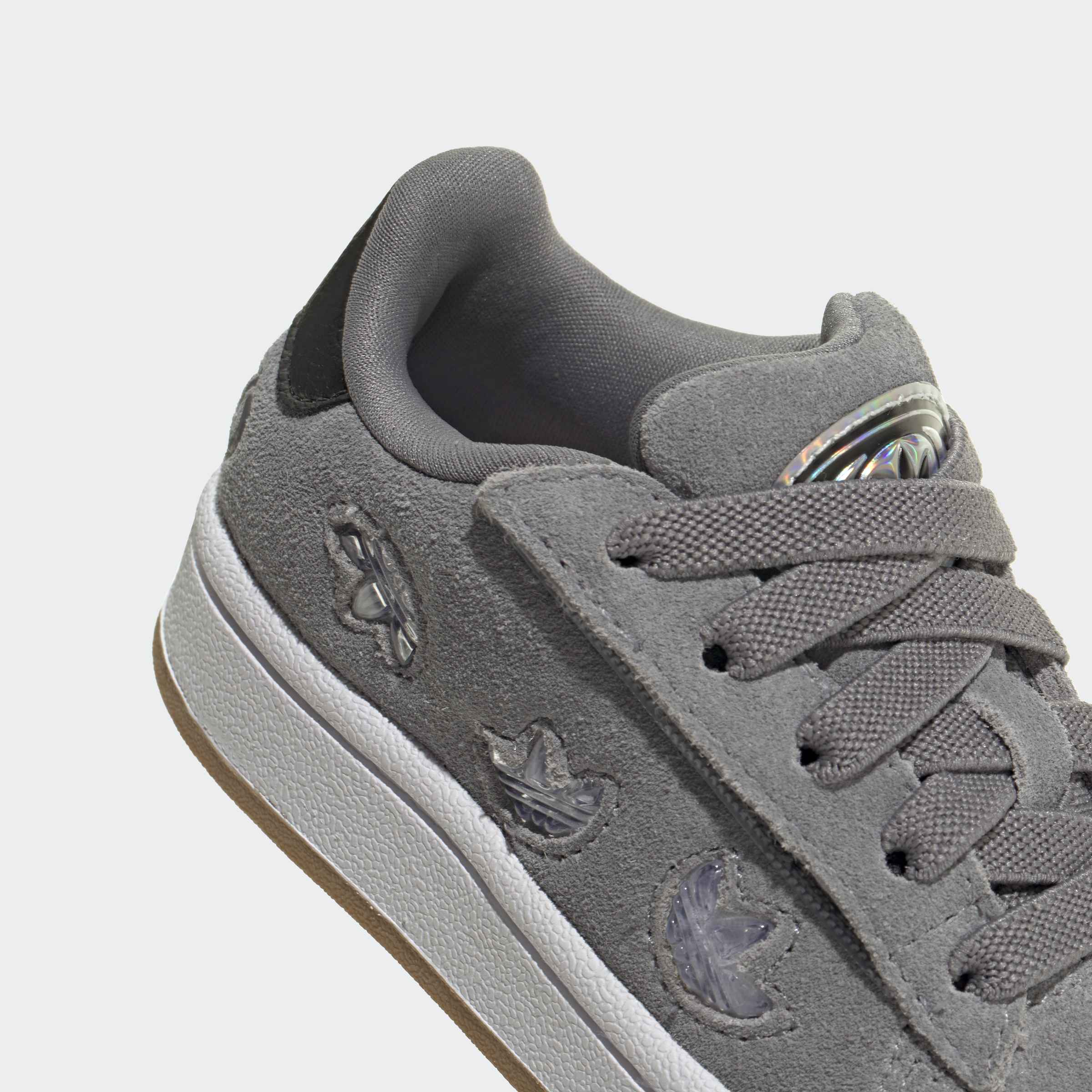 נעל ספורט אפורה עם שרוכים, סוליה לבנה וסמל רקום בצד, בד זמש אופנתי