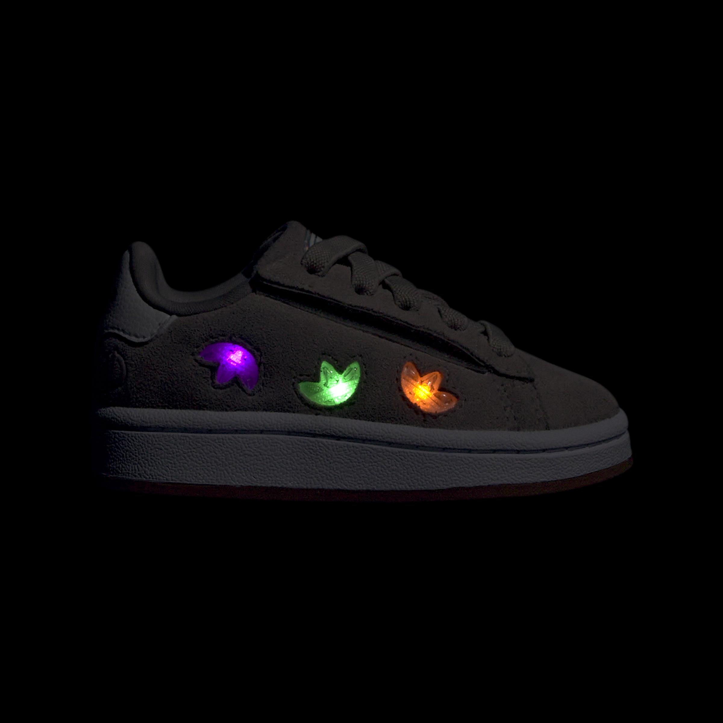 סניקרס אפורות עם עיטורים מוארים בשלושה צבעים, צילום מוצר על רקע שחור