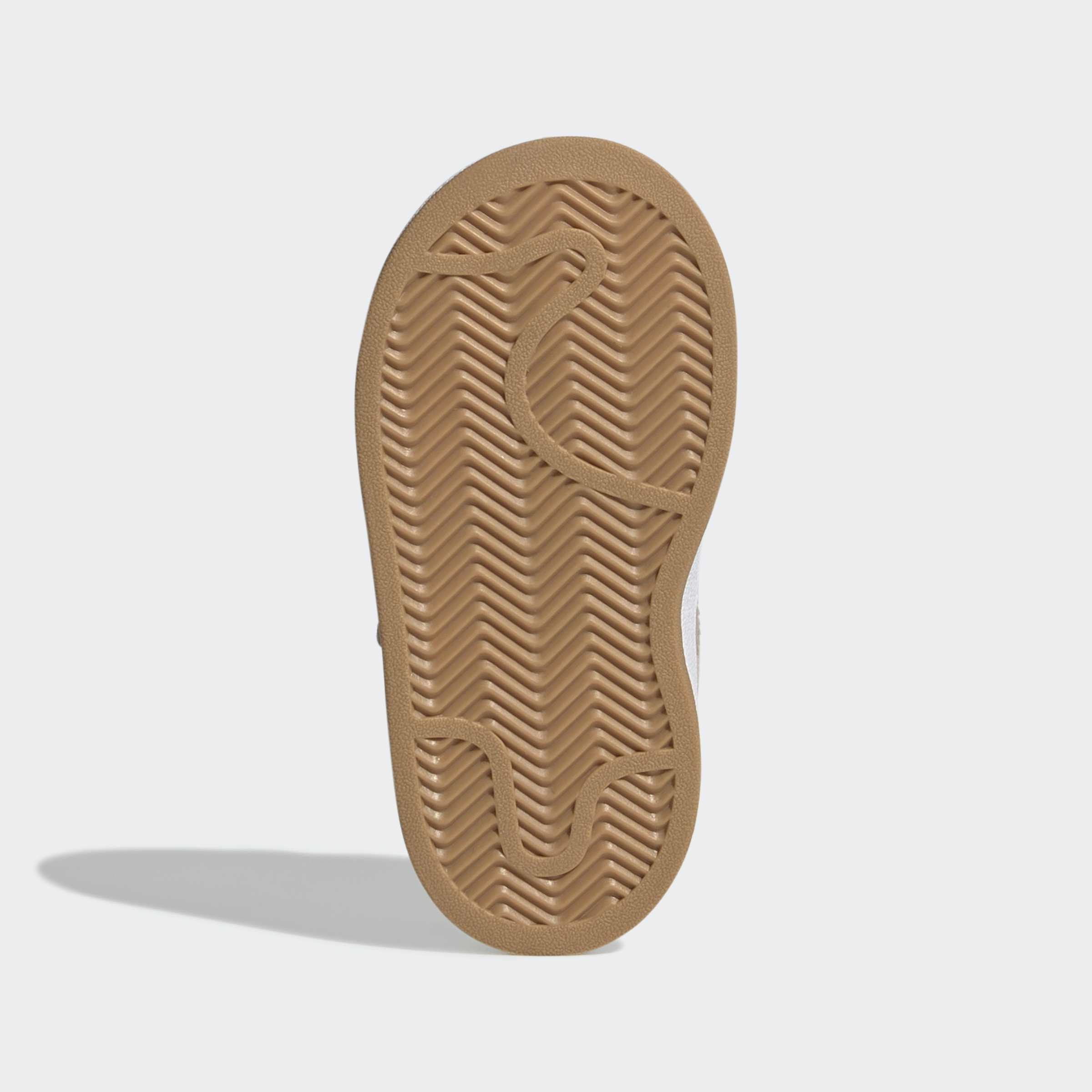 סוליית נעל ספורט בצבע חום עם דפוס זיגזג, על רקע לבן