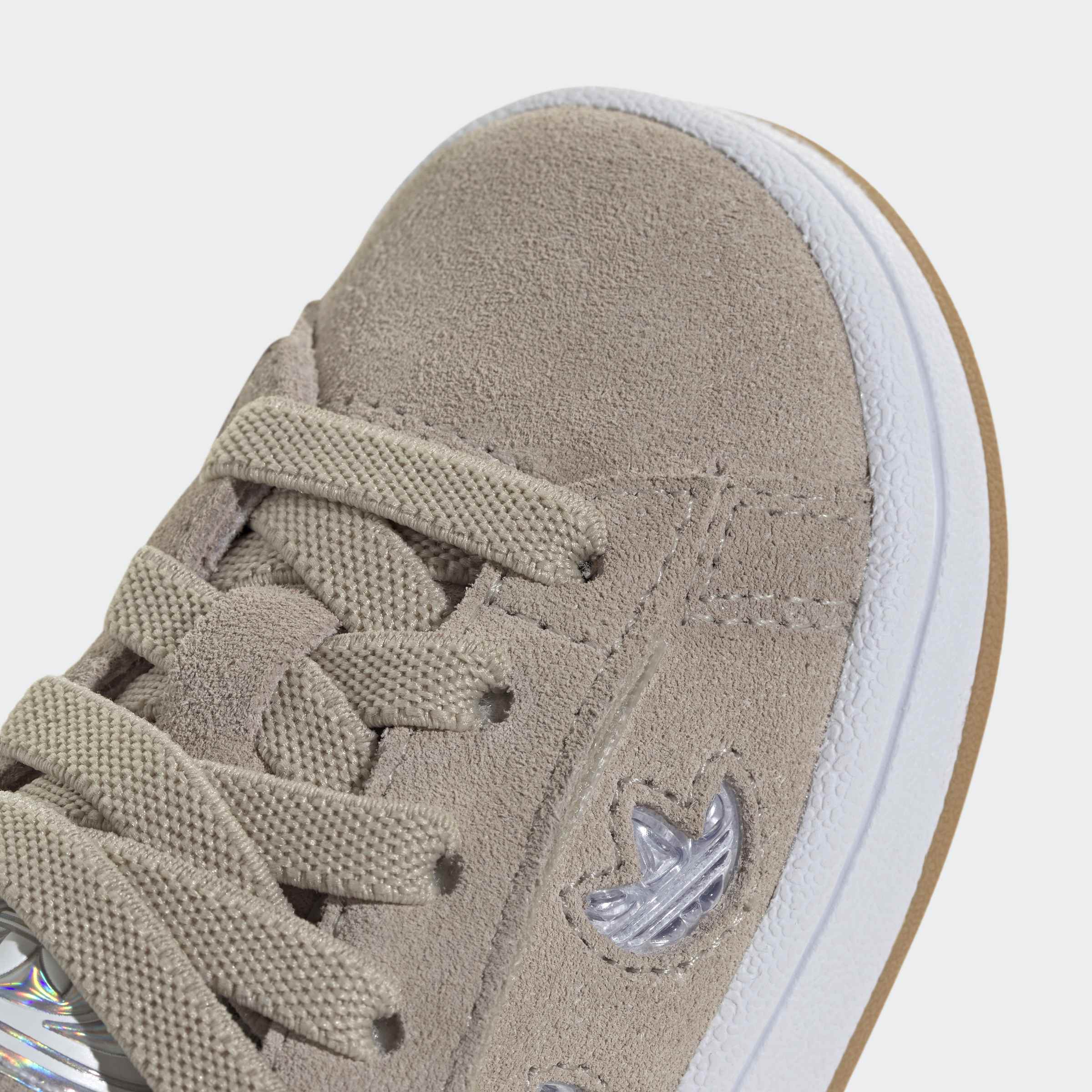 נעלי סניקרס זמש בצבע בז' עם שרוכים, סוליה לבנה ודיטייל לוגו צד, צילום תקריב אופנה