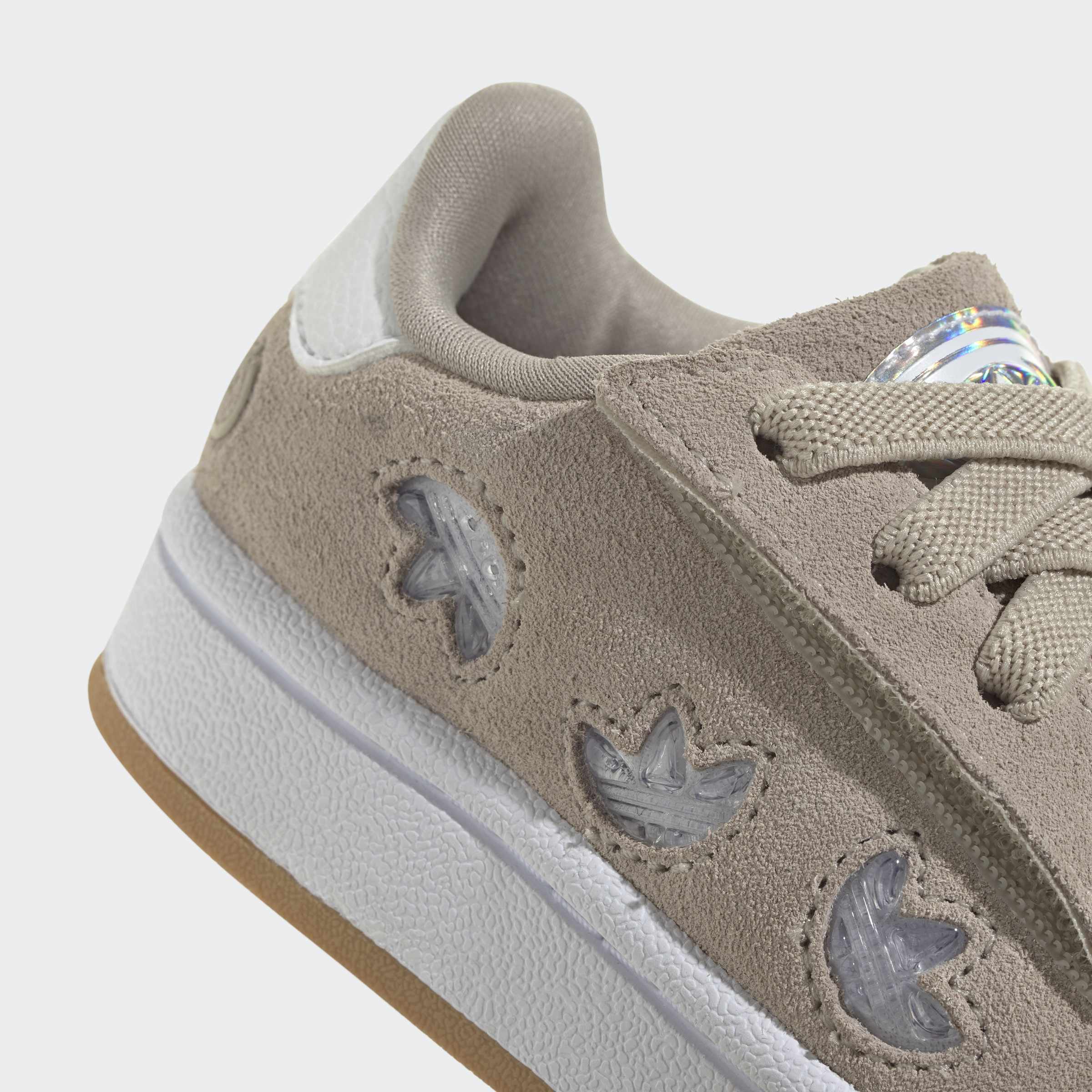 פרט נעל ספורט אפורה עם סוליה לבנה, עיטורי בד רקועים ושרוכים